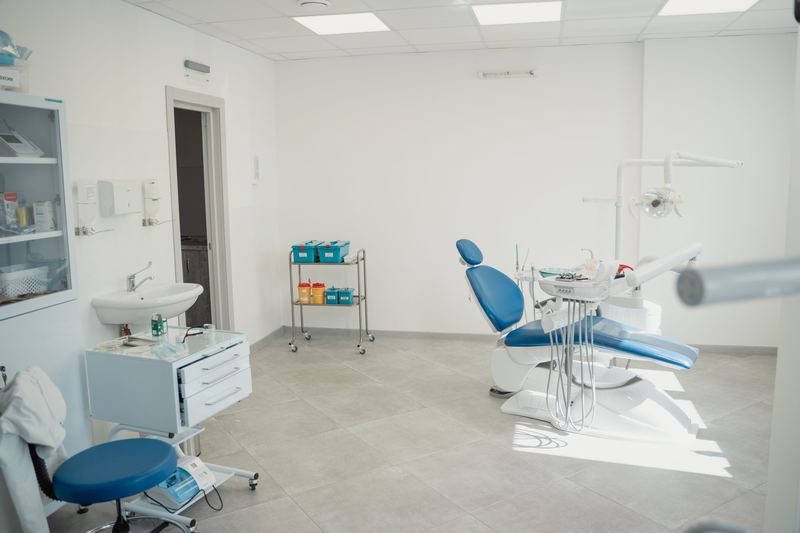 Jasny gabinet zabiegowy z fotelem dentystycznym i oknem